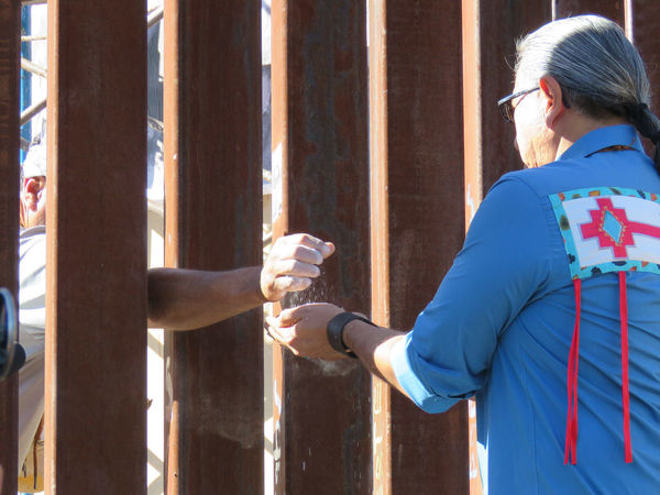 A man receives dirt hands stuck from one side of the wall through the other