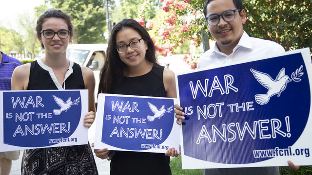 Group of advocates holding "War Is Not The Answer" signs