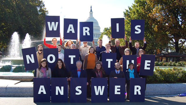 Group of advocates holding "War Is Not The Answer" signs