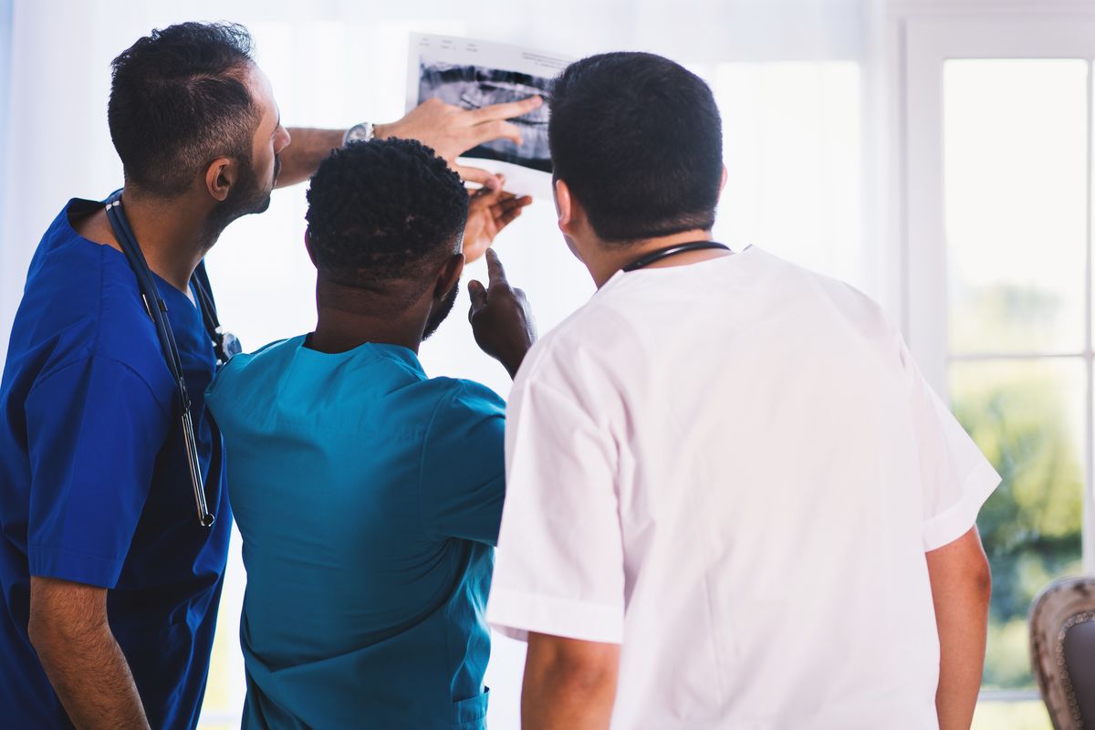 Three doctors looking at an x-ray.