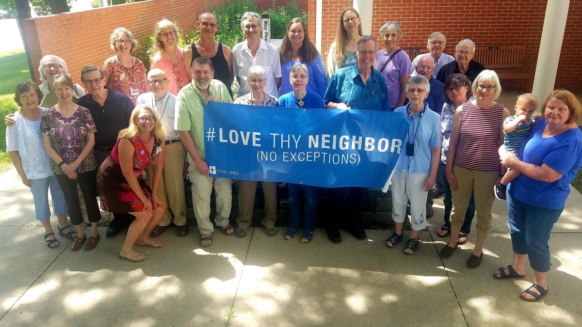 Christine Ashley with Friends holding Love They Neighbor banner