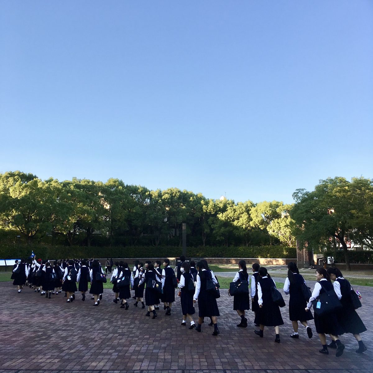 School children walk by the Nagasaki hypocenter cenotaph.