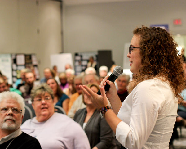 Young person speaking in front of crowd
