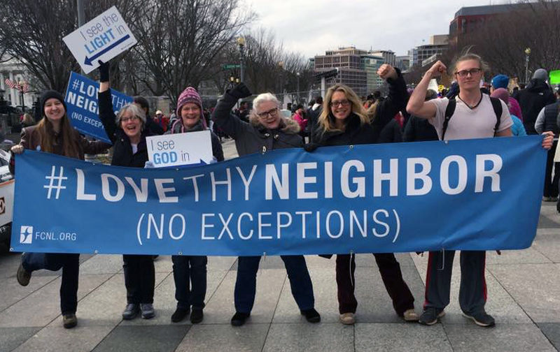 People holding Love They Neighbor Banner at a march.